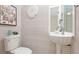 Stylish powder room features a pedestal sink, coastal decor, and attractive striped wallpaper at 2306 64Th W St # 17, Bradenton, FL 34209