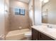 Bathroom with a tiled tub, dark wood vanity and backsplash, and a large mirror over the sink at 235 Dahlia Ct, Bradenton, FL 34212