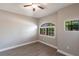 Cozy bedroom with laminate floors, a ceiling fan, and two windows offering natural light and serene views at 235 Dahlia Ct, Bradenton, FL 34212