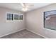 Well-lit bedroom with carpeted floors, two windows, and a ceiling fan at 235 Dahlia Ct, Bradenton, FL 34212
