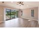 Bright, spacious living room with wood flooring, ceiling fan, and sliding glass doors providing pool views at 235 Dahlia Ct, Bradenton, FL 34212