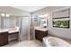 A luxurious main bathroom featuring a glass shower, soaking tub, and dual vanities at 235 Dahlia Ct, Bradenton, FL 34212