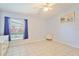 Serene bedroom with tiled floors, soft blue walls, and a bright window with natural light at 2407 New Haven Cir, Sun City Center, FL 33573