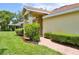 Charming single-story home with brick walkway, manicured greenery, and a well-kept lawn at 2407 New Haven Cir, Sun City Center, FL 33573