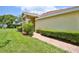 Inviting single-story home with a brick walkway, manicured hedges, and well-maintained lawn at 2407 New Haven Cir, Sun City Center, FL 33573
