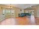 Bright living room featuring hardwood floors, a comfortable blue sofa, and large windows at 2407 New Haven Cir, Sun City Center, FL 33573