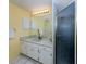 Bathroom with white vanity, large mirror, updated lighting, and a tiled shower at 245 Woodingham Trl, Venice, FL 34292