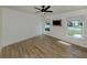 Bright bedroom with hardwood floors, two windows, and modern ceiling fan at 245 Woodingham Trl, Venice, FL 34292