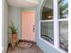 Close-up of the front entrance showcasing a pastel door, a window, and a decorative plant at 245 Woodingham Trl, Venice, FL 34292
