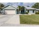 Charming single-story home with a well-maintained lawn, light green exterior, and two-car garage at 245 Woodingham Trl, Venice, FL 34292