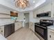 Modern kitchen with stainless steel appliances, white cabinetry, and natural light at 245 Woodingham Trl, Venice, FL 34292