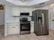 Modern kitchen with stainless steel appliances and white cabinetry at 245 Woodingham Trl, Venice, FL 34292