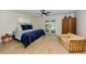 Relaxing main bedroom with a ceiling fan, french doors, and wood floors at 245 Woodingham Trl, Venice, FL 34292