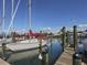 Picturesque marina with sailboats docked along wooden piers and charming waterfront homes under a bright sky at 245 Woodingham Trl, Venice, FL 34292