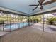 Spacious screened-in patio with a ceiling fan, offering a comfortable view of the backyard and pool at 245 Woodingham Trl, Venice, FL 34292