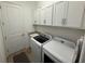 Modern laundry room with white cabinets, granite countertop, washer and dryer at 25240 Keygrass Ct, Punta Gorda, FL 33955