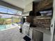 An outdoor kitchen with stainless steel appliances and bar-style countertop overlooks a golf course view at 25240 Keygrass Ct, Punta Gorda, FL 33955