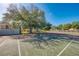 Community basketball court with adjustable hoop surrounded by a fence and mature trees at 3447 Clark Rd # 246, Sarasota, FL 34231