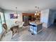 Dining area next to an island and kitchen featuring modern lighting and stainless-steel appliances at 3447 Clark Rd # 246, Sarasota, FL 34231