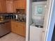 A well-lit kitchen with wooden cabinetry sits beside an in-unit laundry machine at 3447 Clark Rd # 246, Sarasota, FL 34231
