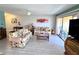 Bright living room with tile floors, floral sofas, ceiling fan, and sliding glass doors to the balcony at 3447 Clark Rd # 246, Sarasota, FL 34231