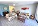Inviting living room featuring tile floors, comfortable floral sofas, and a decorative area rug at 3447 Clark Rd # 246, Sarasota, FL 34231