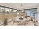 Bright Florida room with round table, wicker chairs, large windows, and view of the lush outdoor landscape at 3941 Glen Oaks E Dr # 32, Sarasota, FL 34232