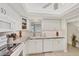Galley kitchen featuring white cabinets, subway tile, updated appliances, and modern fixtures at 3941 Glen Oaks E Dr # 32, Sarasota, FL 34232