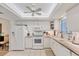 Bright kitchen featuring white appliances, countertops and cabinetry with tile flooring at 3941 Glen Oaks E Dr # 32, Sarasota, FL 34232