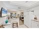 Stylish kitchen boasts white appliances, stone countertops, and a breakfast bar open to the dining area at 3941 Glen Oaks E Dr # 32, Sarasota, FL 34232