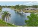 Scenic aerial view of a serene lake with fountain, surrounded by lush greenery and condo community at 3941 Glen Oaks E Dr # 32, Sarasota, FL 34232