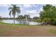 Scenic view of a tranquil pond with a fountain, surrounded by lush greenery and well-maintained lawns at 3941 Glen Oaks E Dr # 32, Sarasota, FL 34232