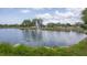 Picturesque view of a serene pond with a fountain, surrounded by lush landscaping at 3941 Glen Oaks E Dr # 32, Sarasota, FL 34232