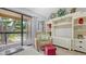 Bright living room with a sliding glass door to the balcony and stylish built-in shelving at 4009 Crockers Lake Blvd # 22, Sarasota, FL 34238