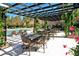 Outdoor patio area has tables, chairs and a pergola covered with flowering vines at 4009 Crockers Lake Blvd # 22, Sarasota, FL 34238