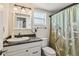 Cozy bathroom featuring a granite countertop, updated fixtures, and a shower with a decorative curtain at 4015 Lake Bayshore Dr # 108, Bradenton, FL 34205