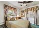 Bedroom with bed, floral curtains, and side table with a view to the trees outdoors at 4015 Lake Bayshore Dr # 108, Bradenton, FL 34205
