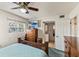 Comfortable bedroom featuring a ceiling fan, wooden furniture, a television, and a view of the lake through the window at 4015 Lake Bayshore Dr # 108, Bradenton, FL 34205