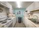 Functional kitchen with white cabinets, tile floors, and essential appliances providing a practical cooking space at 4015 Lake Bayshore Dr # 108, Bradenton, FL 34205