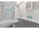 Updated bathroom with tub, shower, white marble tile, and gray vanity with modern fixtures at 4233 Abaco Ct, New Port Richey, FL 34653