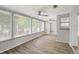 Spacious sunroom with bright natural light from many windows, with wood floors and a ceiling fan at 4233 Abaco Ct, New Port Richey, FL 34653
