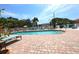 Community pool with brick surround, lounge chairs, and well-maintained landscaping at 4264 Central Sarasota Pkwy # 116, Sarasota, FL 34238
