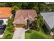 Aerial view of home with a tile roof, garage, and lush landscaping at 4435 Beauchamp Ct, Sarasota, FL 34243