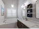 Spa-like bathroom with a soaking tub, double vanity, modern lighting, and neutral decor at 4435 Beauchamp Ct, Sarasota, FL 34243