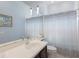 Bathroom with blue walls, large mirror, white vanity, toilet and shower with a decorative blue and white shower curtain at 4435 Beauchamp Ct, Sarasota, FL 34243