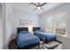 Cozy bedroom with two twin beds, a ceiling fan, plantation shutters, and a decorative rug at 4435 Beauchamp Ct, Sarasota, FL 34243