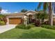 Charming home with a well-manicured lawn, lush landscaping, and a stylish wood garage door at 4435 Beauchamp Ct, Sarasota, FL 34243