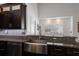 Close-up of a kitchen showcasing stainless steel sink, granite countertops, and ample lighting at 4435 Beauchamp Ct, Sarasota, FL 34243