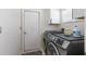 Functional laundry room with a side-by-side washer and dryer, white cabinets and a small patterned rug at 4435 Beauchamp Ct, Sarasota, FL 34243