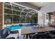 Beautiful screened pool area with a dining table, chairs, view of the backyard and lush tropical landscaping at 4435 Beauchamp Ct, Sarasota, FL 34243